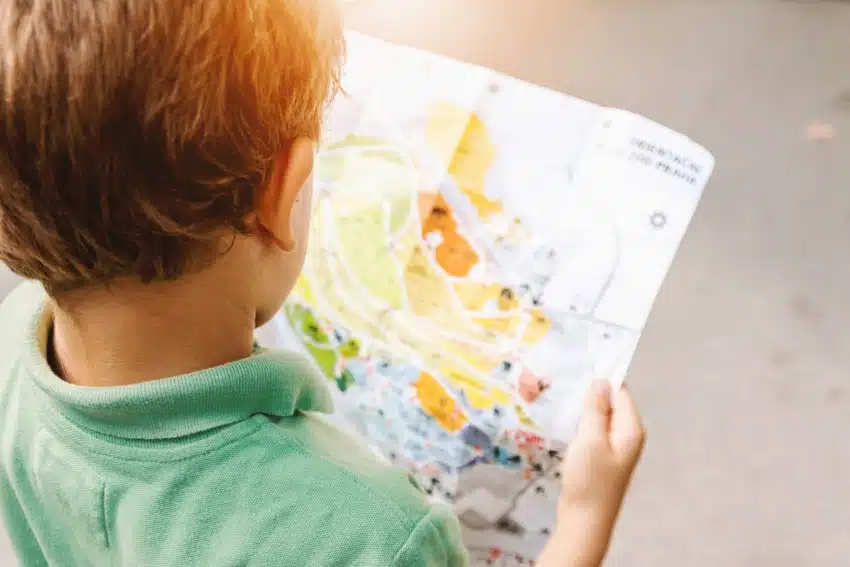 Homeschooled boy using a map to study