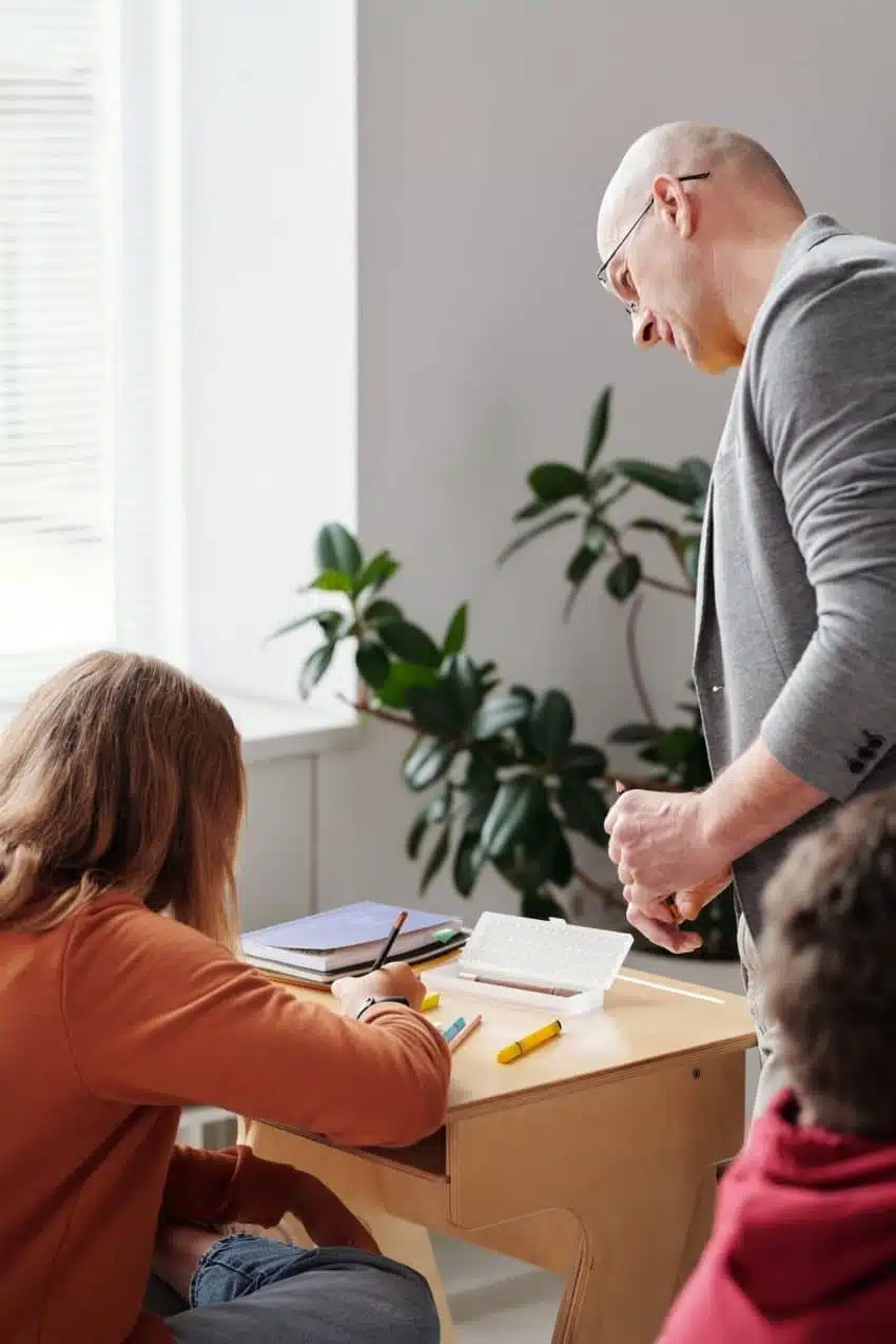 Profesor revisando el trabajo de los estudiantes para ayudarlos a aprender