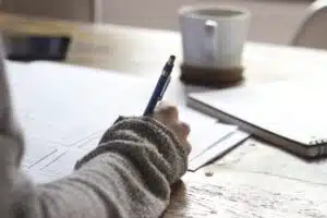 Woman at a desk writing.