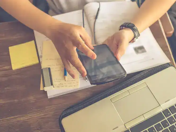 a college student's study desk with mobile phone and laptop