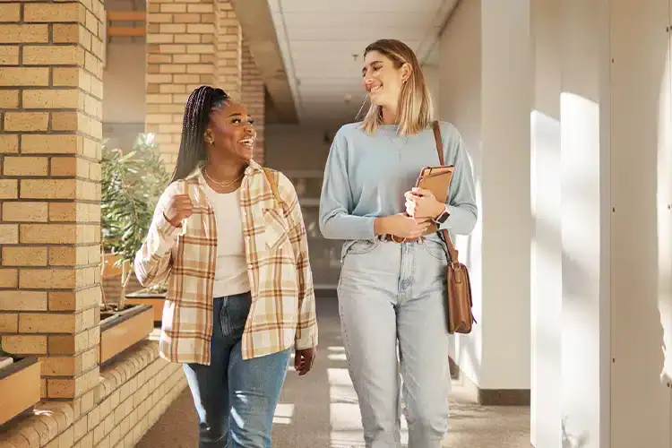 deux étudiantes d'un collège communautaire discutant et marchant dans les couloirs de l'établissement