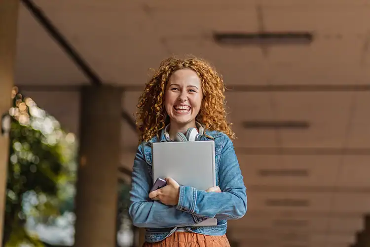 a female associate degree student clutching a notebook in her hands